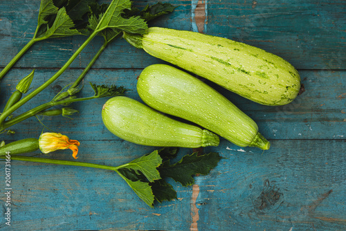 Harvest of green courgette top view on wooden surface