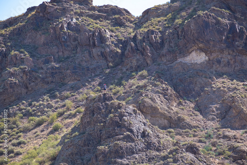 Fotografía Hiker standing on top of a rocky mountain cliff edge