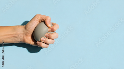 woman hand squeezing a stress ball. Relief of tension and anxiety concept. Exercise for strengthening finger muscle and improving grip. Mental health support and emotional calm tool