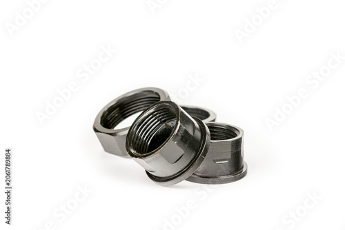 Large metal nuts painted black. Four large metal nuts. Close-up on a white background.