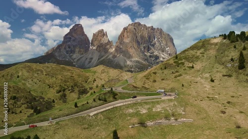 Mountain road winding through green alpine hills under bright daylight