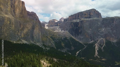 Towering mountain cliffs above a forested alpine valley