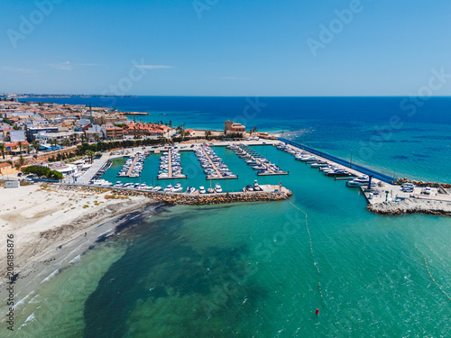 Aerial view Torre de la Horadada town with marina filled with boats docked in Mediterranean Sea harbor. Tourist resort, travel destinations concept. Costa Blanca, Alicante province, Spain