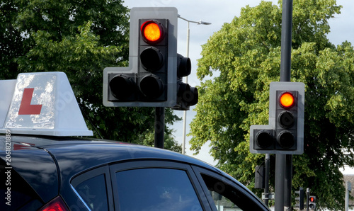 Fotografía Learner driver car with L plate at red traffic light, driving school lesson, sto