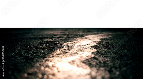 Dark grainy asphalt texture with soft glowing light streak for background