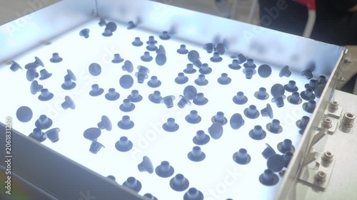 Close up view: automatic inspection vibration table with lighting for sorting or quality control at factory or exhibition . Inspection, identification, measuring and controlling concept