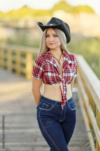 Adult woman in hat and plaid shirt outdoors