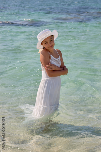 Young girl standing sideways in shallow sea water