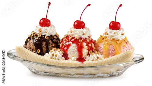 Classic banana split with three ice cream scoops, sauces, whipped cream, cherries and nuts served in a glass dish