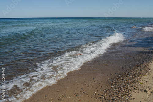 A beach on the Baltic Sea, the atmosphere of the sea, waves at the shore, stones in the water
