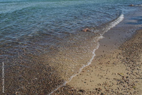 A beach on the Baltic Sea, the atmosphere of the sea, waves at the shore, stones in the water
