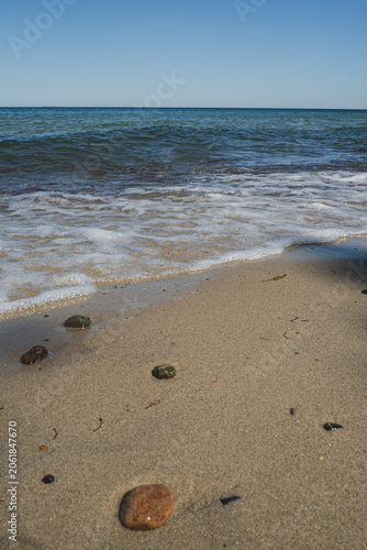 A beach on the Baltic Sea, the atmosphere of the sea, waves at the shore, stones in the water
