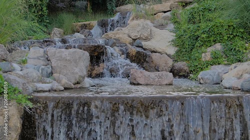Slow motion: river or stream of water is flowing and falling down - artificial waterfall in the park in Istanbul, Turkey. Nature, landscape and environment concept