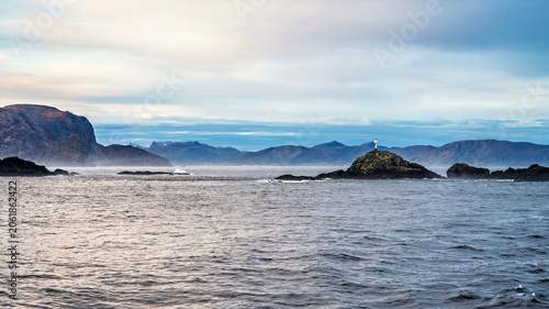 Landscape in Norway with a small lighthouse, seen from a big ship