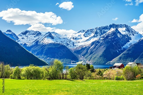 Landscape around the Hjorundfjord in Norway with mountains, and green fields on a sunny day