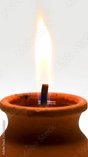 Candle flame rising from lit ceramic candle holder