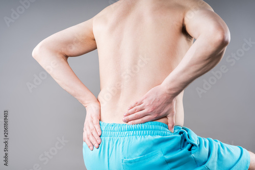 Back pain, kidney stones, inflammation and disease, man suffering from backache on grey background