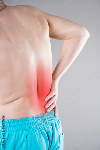 Back pain, kidney stones, inflammation and disease, man suffering from backache on grey background