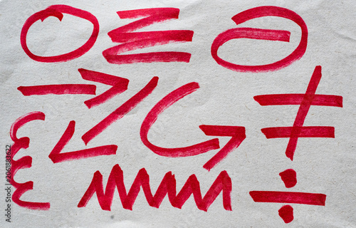 Fotografie Conjunto de trazos y símbolos abstractos rojos pintados a mano sobre papel textu