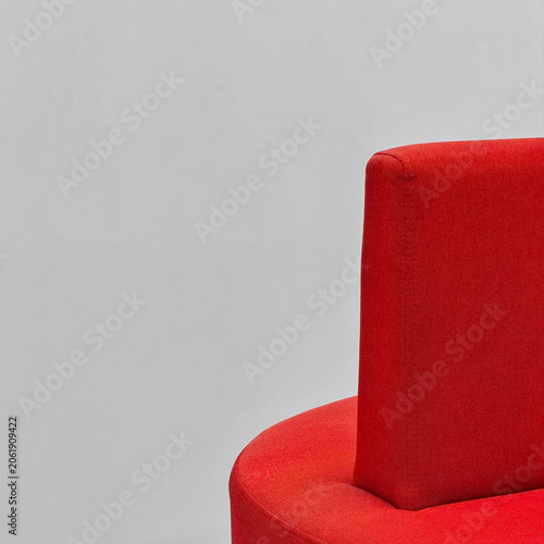 Modern red upholstered chair against a plain gray background