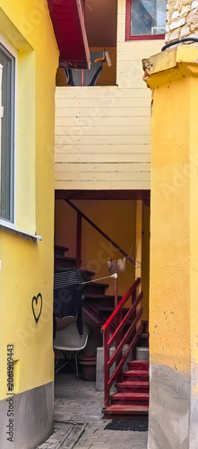 Colorful urban staircase with yellow walls and red steps in alleyway