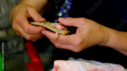 Mature woman slicing traditional pork lard from plastic bag for homemade sandwich preparation