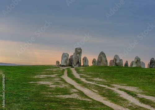 Foto Megalithic monument Ale's Stones standing on a green hill at sunset Sweden