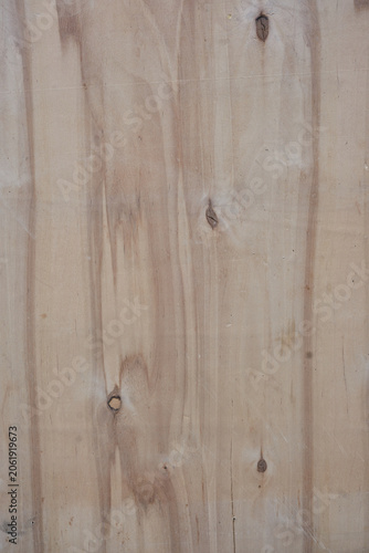 Detailed close-up texture of weathered plywood with deep vertical cracks and unique organic grain patterns. 
