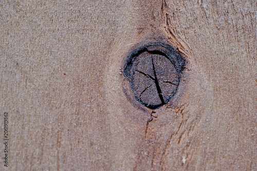 Texture of old rugged wood panel featuring deep cracks and beautiful organic grain lines. Dark brown weathered plywood surface with natural splinters, showing signs of industrial use and age decay