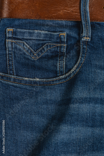 Closeup of denim jeans with pocket and belt showing fabric texture