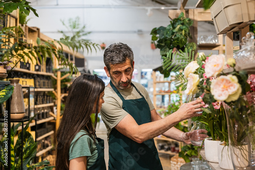 Garden center workers arranging flowers and plants