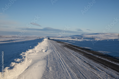 Winter road through the endless snowy tundra. Murmansk-Teriberka Road, Arctic Circle, Russia
