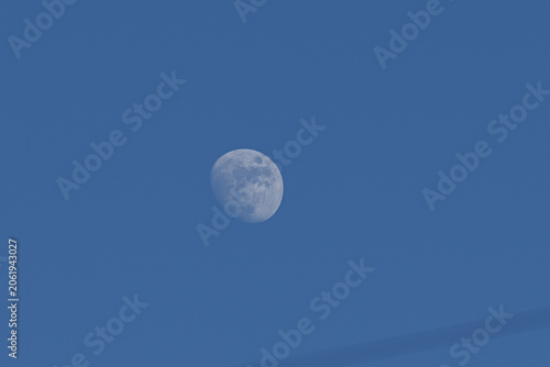 Foto Waning gibbous moon visible in the bright blue sky during daytime