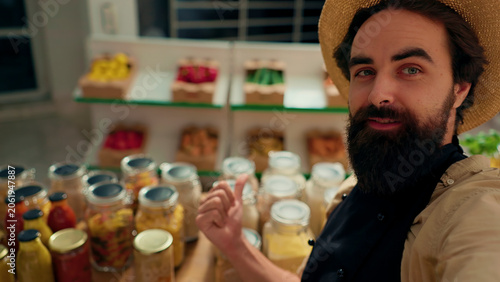 Obraz na plátne Man films vlog praising hidden gem sustainable local neighborhood supermarket, impressed by high quality vegan products