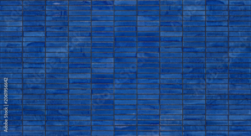 High angle view of modern dark blue mosaic rectangular ceramic tiles arranged in a neat geometric pattern for bathroom kitchen wall decoration.