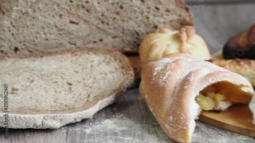 On the table are fresh bread and pastries, apple buns, pies, and croissants. Fresh, warm pastries topped with cheese are displayed in the bakery's display case.