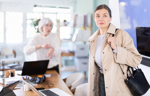 Fotografie Elderly woman sternly scolds her adult female colleague for being late for work