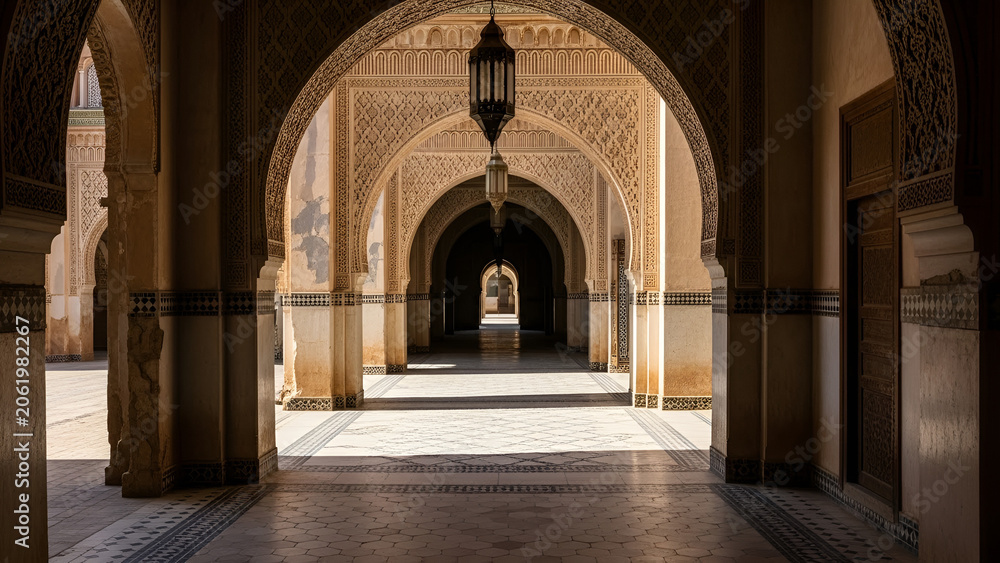 Obraz premium A majestic hallway with intricately designed arches and columns, adorned with ornate patterns and a hanging lantern in warm sunlight.