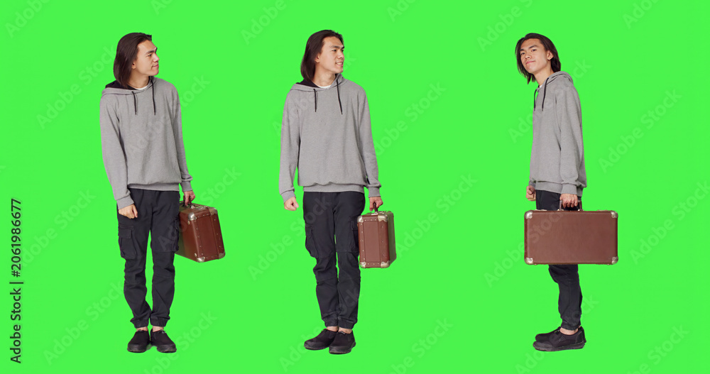 Obraz premium Person waiting impatiently in studio, looking around and checking hour on wristwatch, young adult carrying retro briefcase standing over full body green screen backdrop, acting impatient.