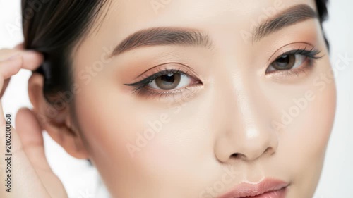 Asian Woman's Elegant Portrait: A captivating close-up portrait of an East Asian woman showcasing flawless makeup, with striking eyes and perfectly sculpted brows.