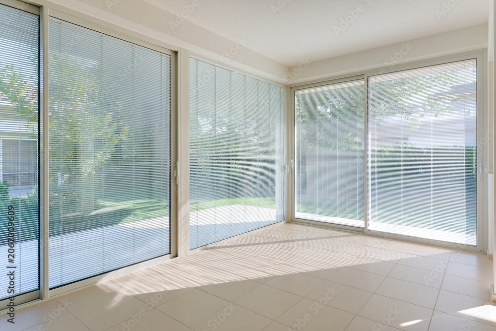 Obraz premium Bright empty modern living room with large sliding glass windows