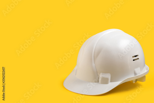 White hardhat on yellow bac...