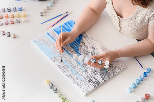 Young woman with painting b...