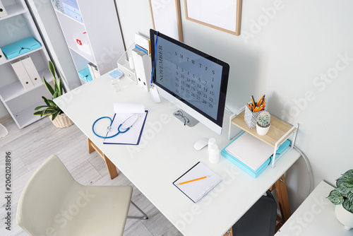 Computer monitor with calendar on doctors desk in medical office