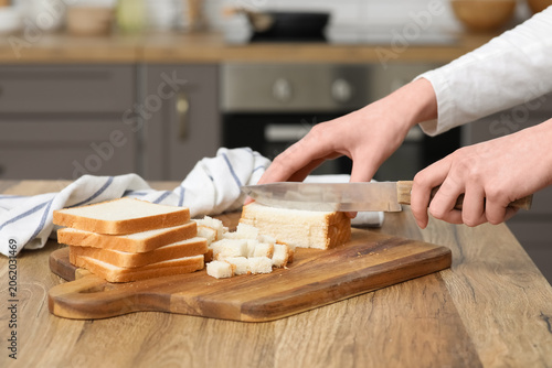 Young woman cutting fresh b...