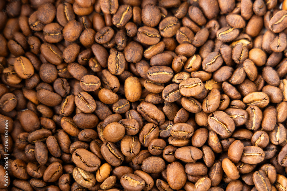 Fototapeta premium Background filled with perfectly roasted Arabica coffee beans, capturing the aromatic essence and rich coffee tradition of Colombia.
