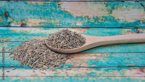 dry cumin seed in spoon on old vintage background top view.ai 