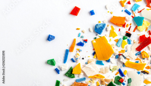 Colorful Plastic Fragments: A vibrant scattering of small, broken pieces of multi-colored plastic on a white background, creating a textured abstract pattern.