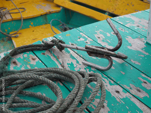 A weathered anchor and coiled rope rest on the deck of a rustic boat, hinting at journeys taken and adventures waiting.