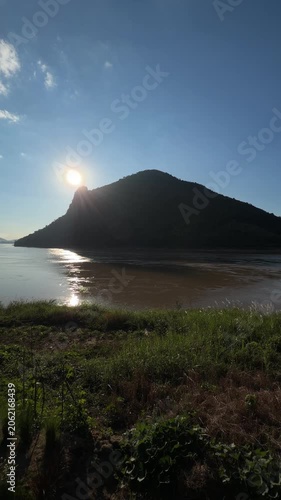 Scenic sunburst over mountain and river landscape